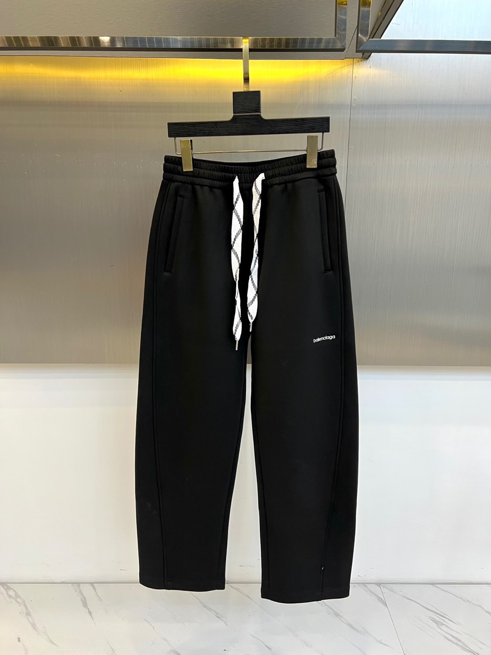 BALENCIAGA巴黎世家、2025秋冬新品男士休闲弯刀裤，这款休闲裤采用标志性弯刀版型设计，立体剪裁