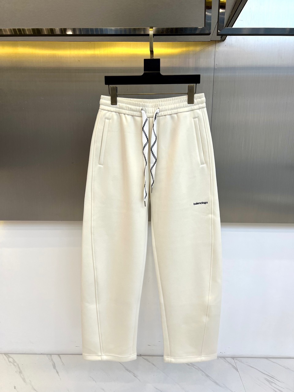 BALENCIAGA巴黎世家、2025秋冬新品男士休闲弯刀裤，这款休闲裤采用标志性弯刀版型设计，立体剪裁