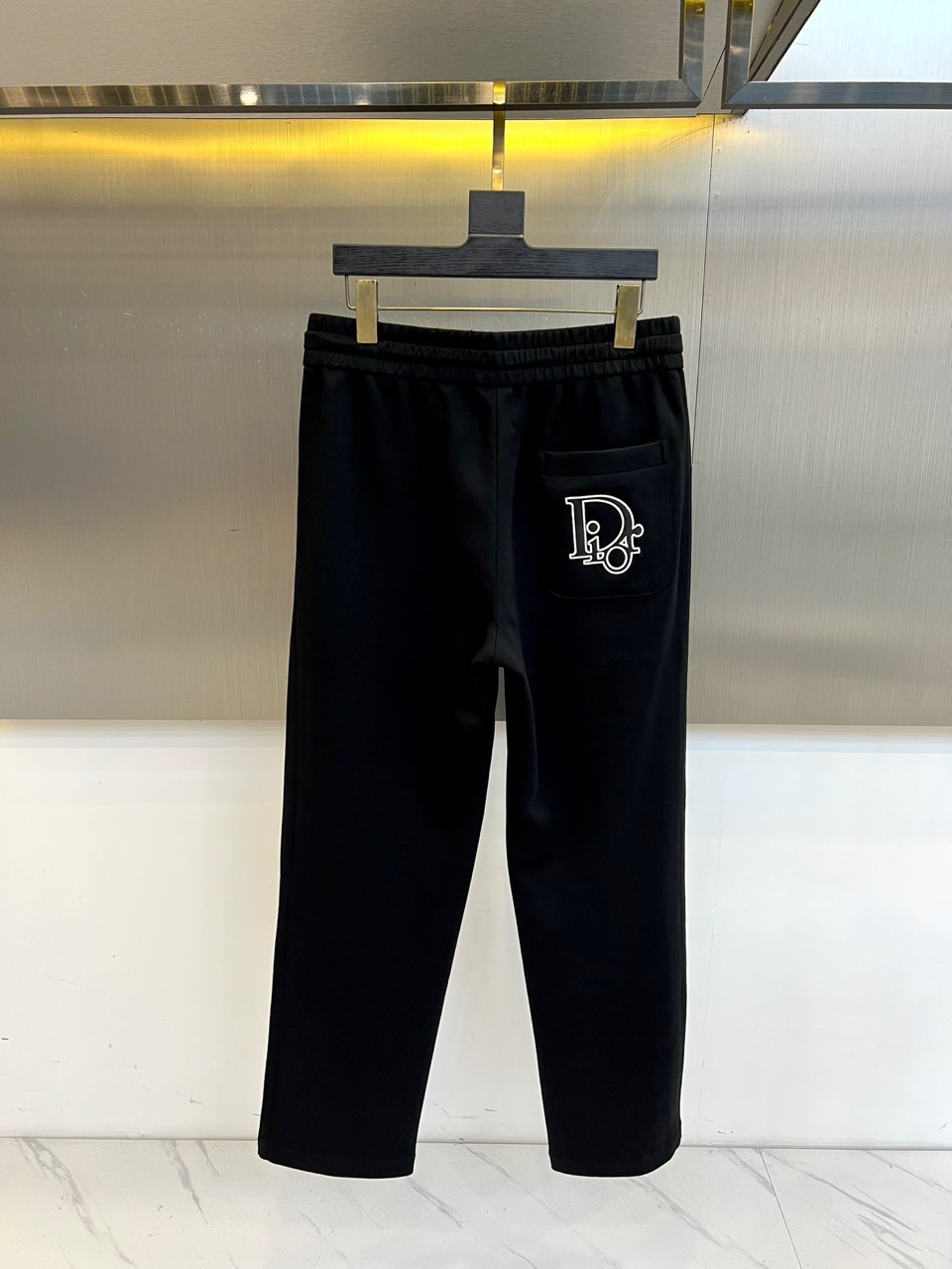 Dio迪奥、2025秋冬新品迪奥风格休闲裤。这款休闲裤采用迪奥标志性设计，右腿饰有经典CD徽标，抽绳腰头