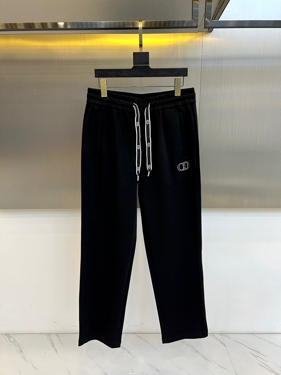 Dio迪奥、2025秋冬新品迪奥风格休闲裤。这款休闲裤采用迪奥标志性设计，右腿饰有经典CD徽标，抽绳腰头
