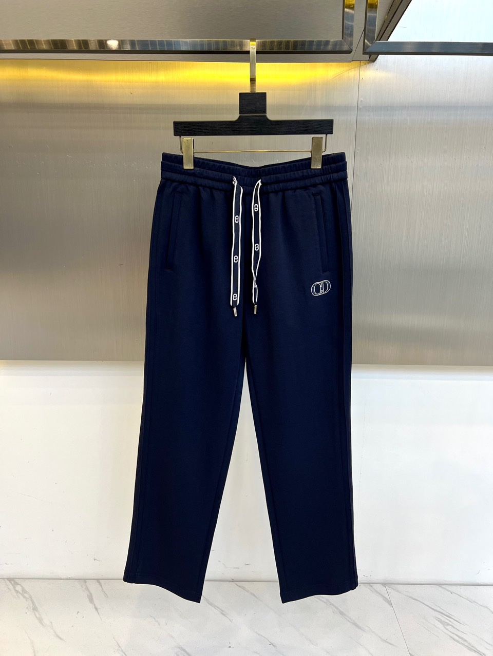 Dio迪奥、2025秋冬新品迪奥风格休闲裤。这款休闲裤采用迪奥标志性设计，右腿饰有经典CD徽标，抽绳腰头