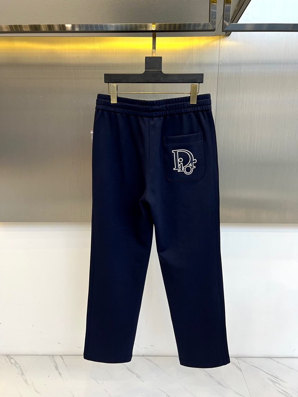 Dio迪奥、2025秋冬新品迪奥风格休闲裤。这款休闲裤采用迪奥标志性设计，右腿饰有经典CD徽标，抽绳腰头