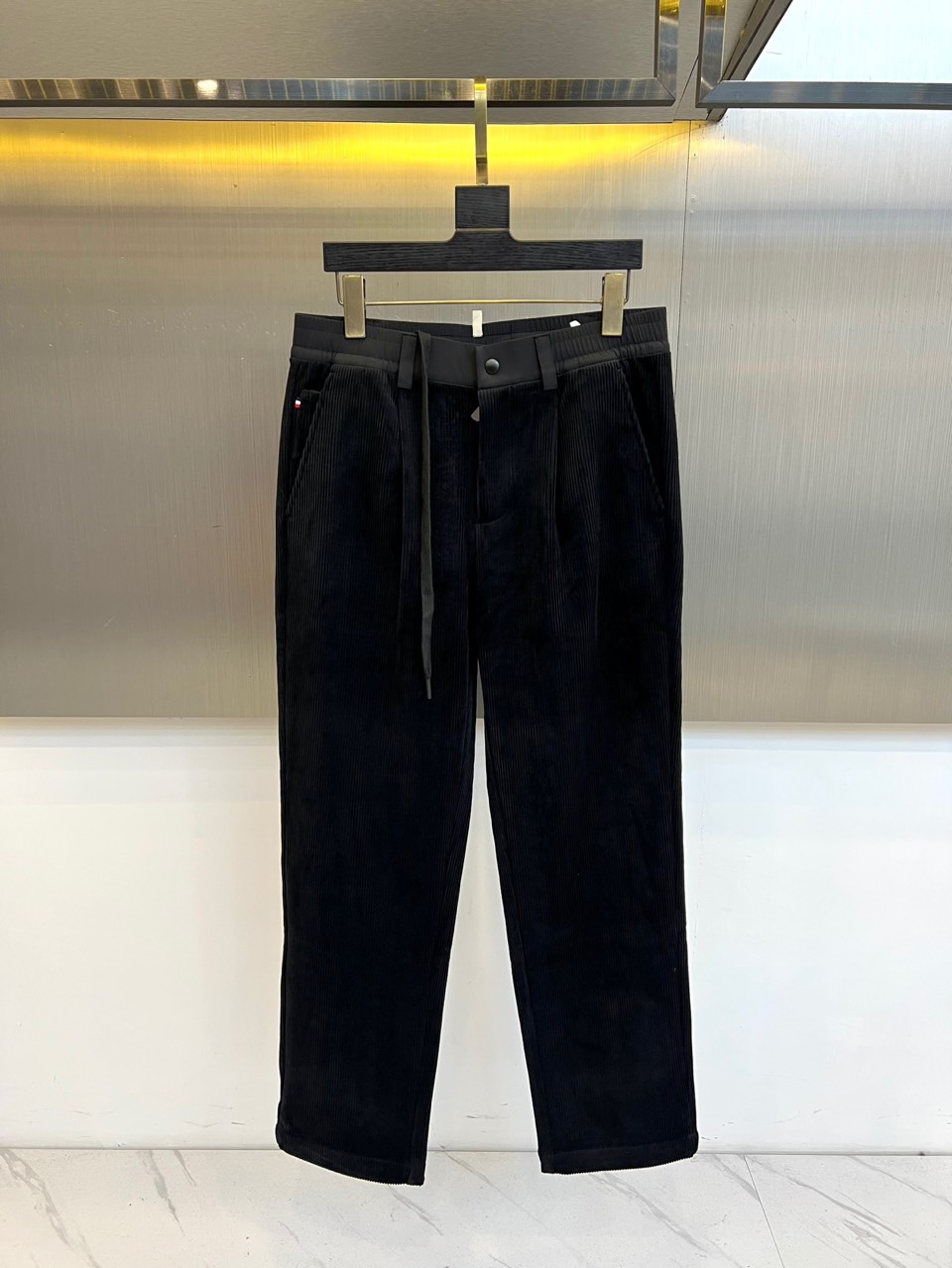 Mon蒙口、2025秋冬新品 蒙口休闲长裤。色调搭配灯芯绒质感面料，表面细密竖条纹肌理凸显复古时尚感。腰