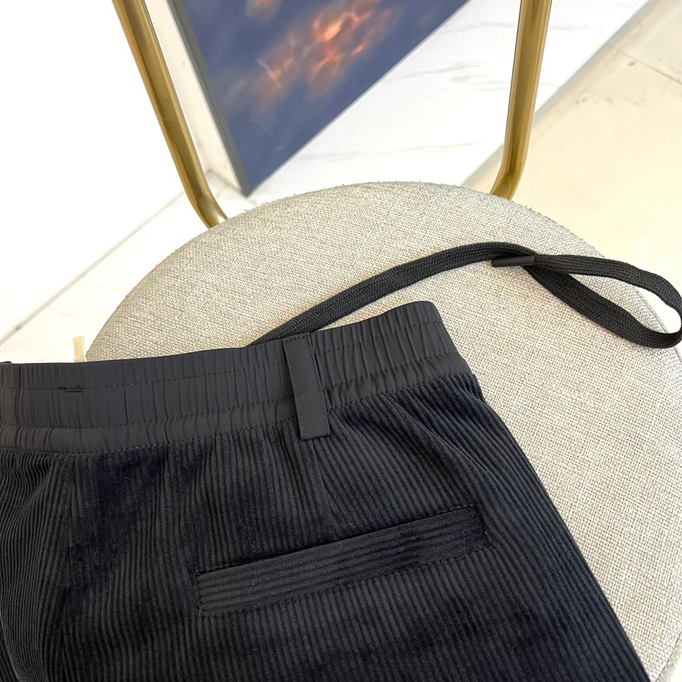 Mon蒙口、2025秋冬新品 蒙口休闲长裤。色调搭配灯芯绒质感面料，表面细密竖条纹肌理凸显复古时尚感。腰