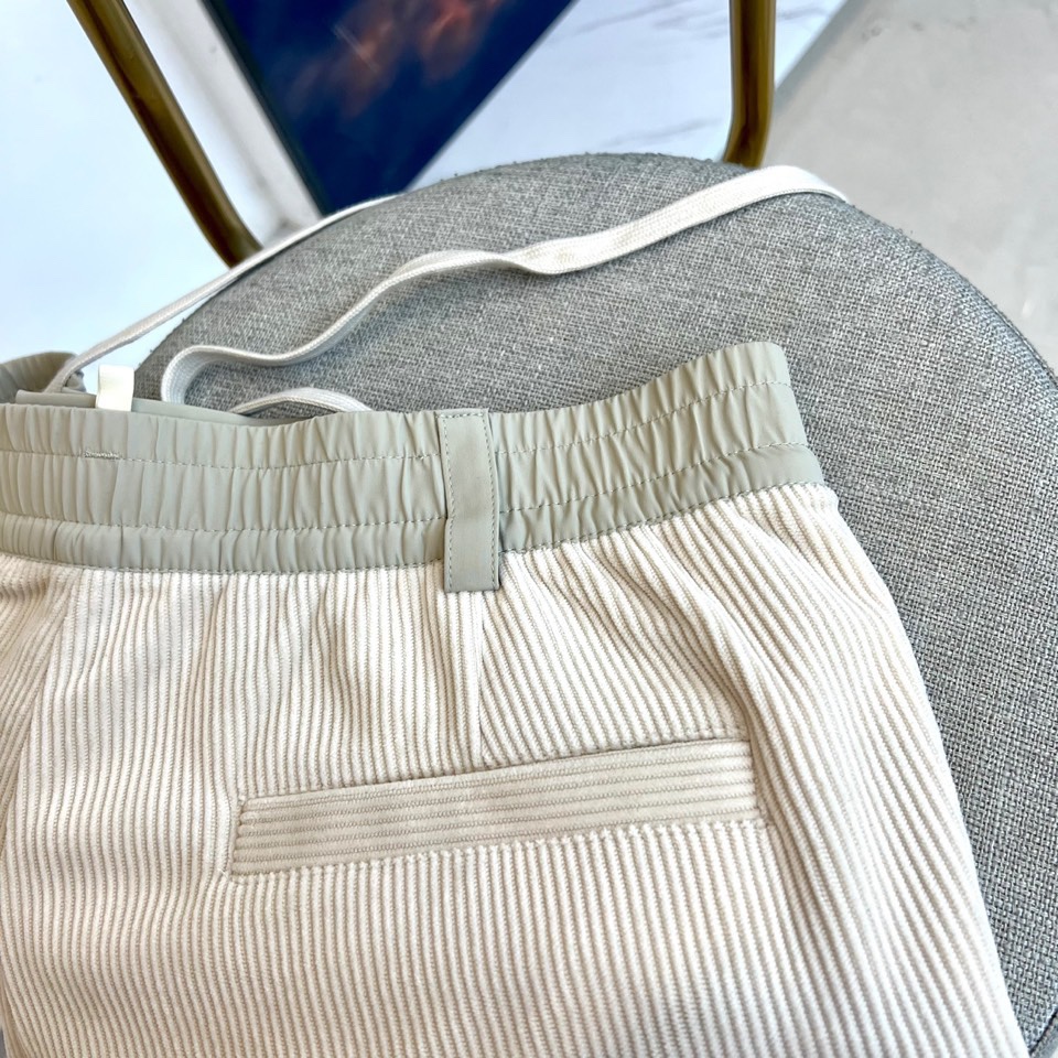 Mon蒙口、2025秋冬新品 蒙口休闲长裤。色调搭配灯芯绒质感面料，表面细密竖条纹肌理凸显复古时尚感。腰