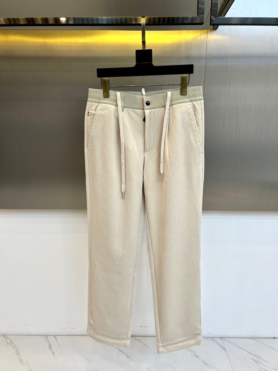Mon蒙口、2025秋冬新品 蒙口休闲长裤。色调搭配灯芯绒质感面料，表面细密竖条纹肌理凸显复古时尚感。腰