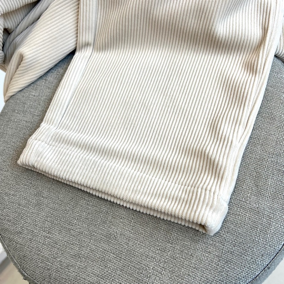 Mon蒙口、2025秋冬新品 蒙口休闲长裤。色调搭配灯芯绒质感面料，表面细密竖条纹肌理凸显复古时尚感。腰