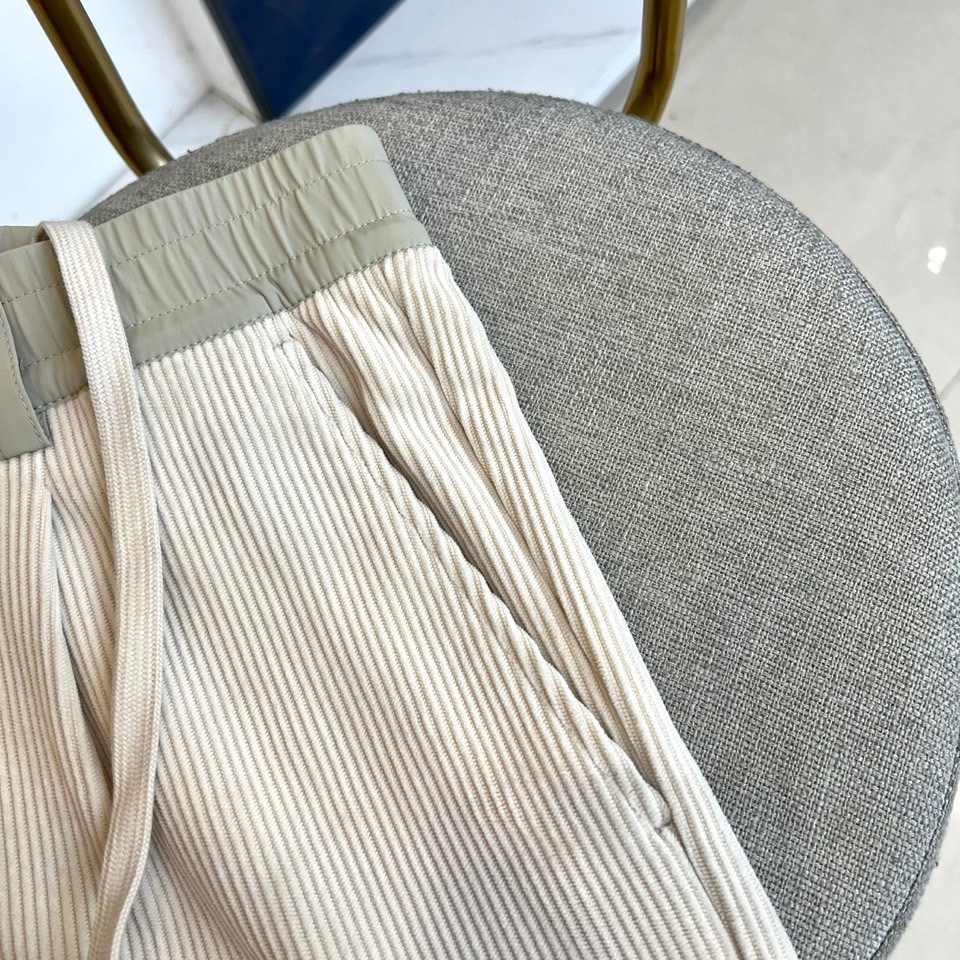 Mon蒙口、2025秋冬新品 蒙口休闲长裤。色调搭配灯芯绒质感面料，表面细密竖条纹肌理凸显复古时尚感。腰