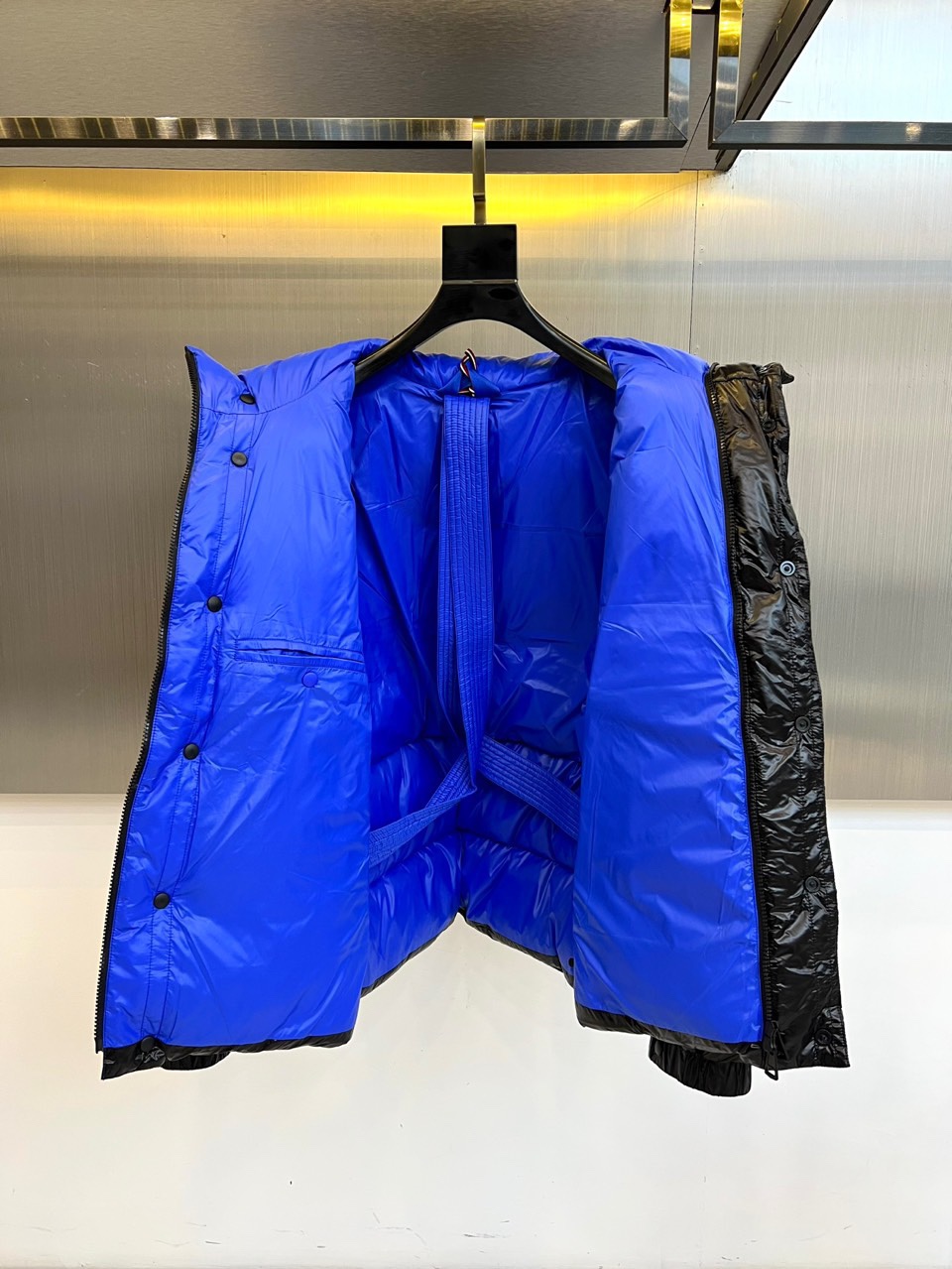 Mon蒙口、2025秋冬新品MONCLER曜黑机能羽绒服。本品以高光泽黑色锦纶面料打造科技质感，亮蓝色内