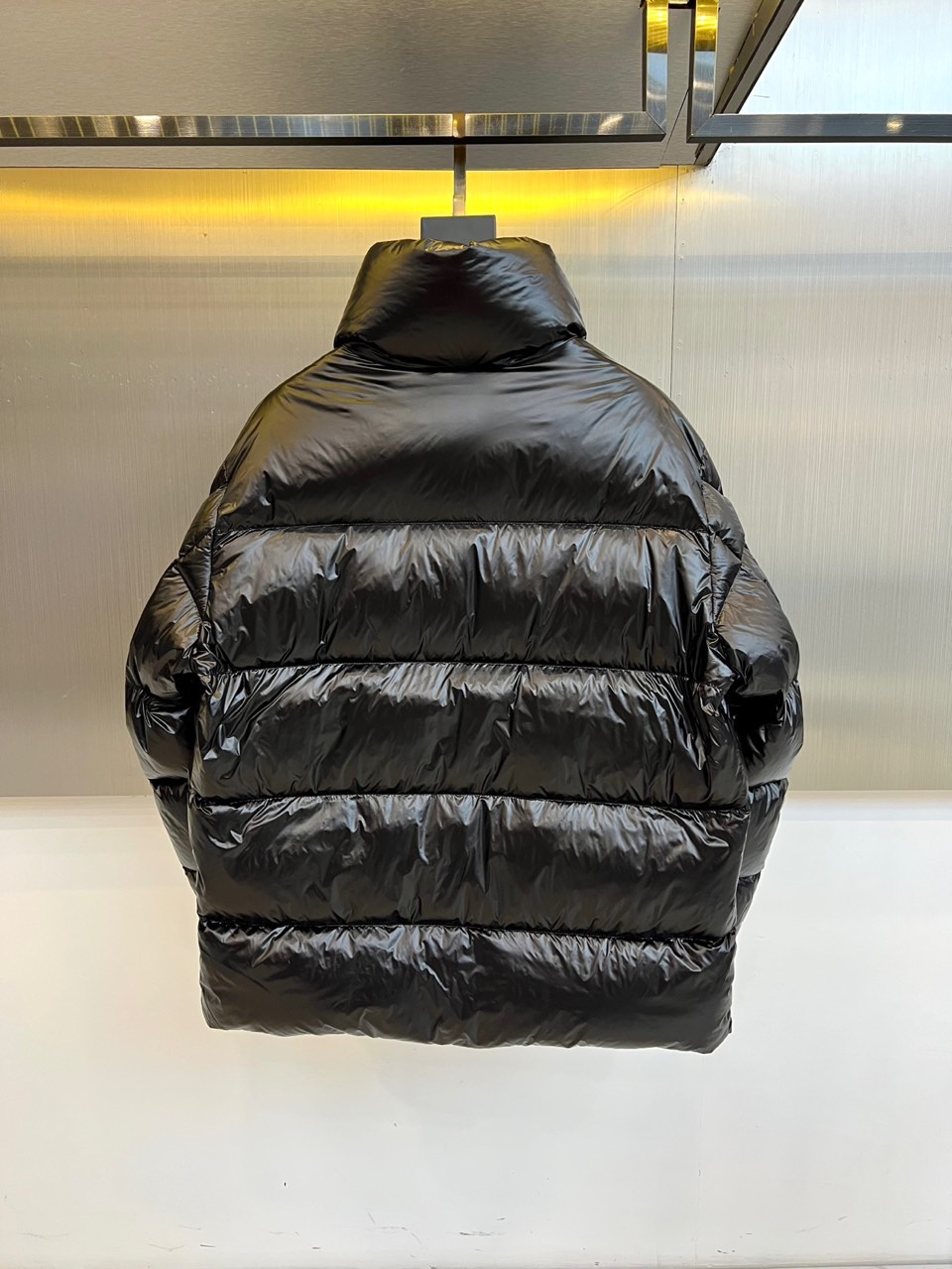 Mon蒙口、2025秋冬新品MONCLER曜黑机能羽绒服。本品以高光泽黑色锦纶面料打造科技质感，亮蓝色内