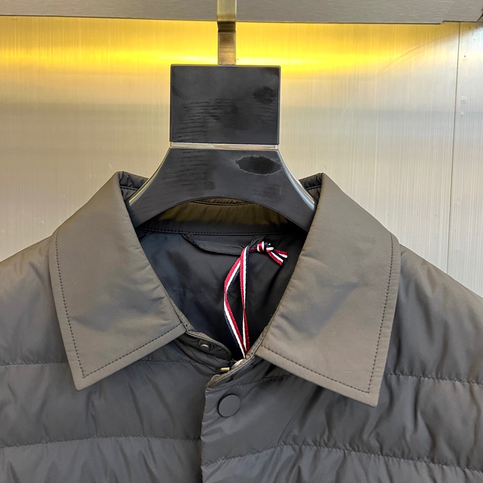 Mon蒙口、2025秋冬新品 MONCLER曜黑经典羽绒服。这款黑色羽绒服采用翻驳领设计，领口内侧饰有红