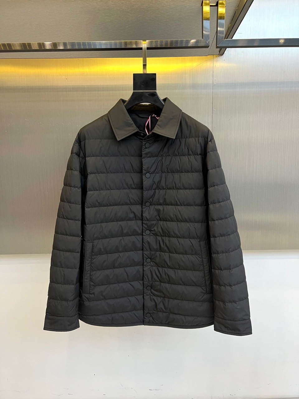 Mon蒙口、2025秋冬新品 MONCLER曜黑经典羽绒服。这款黑色羽绒服采用翻驳领设计，领口内侧饰有红