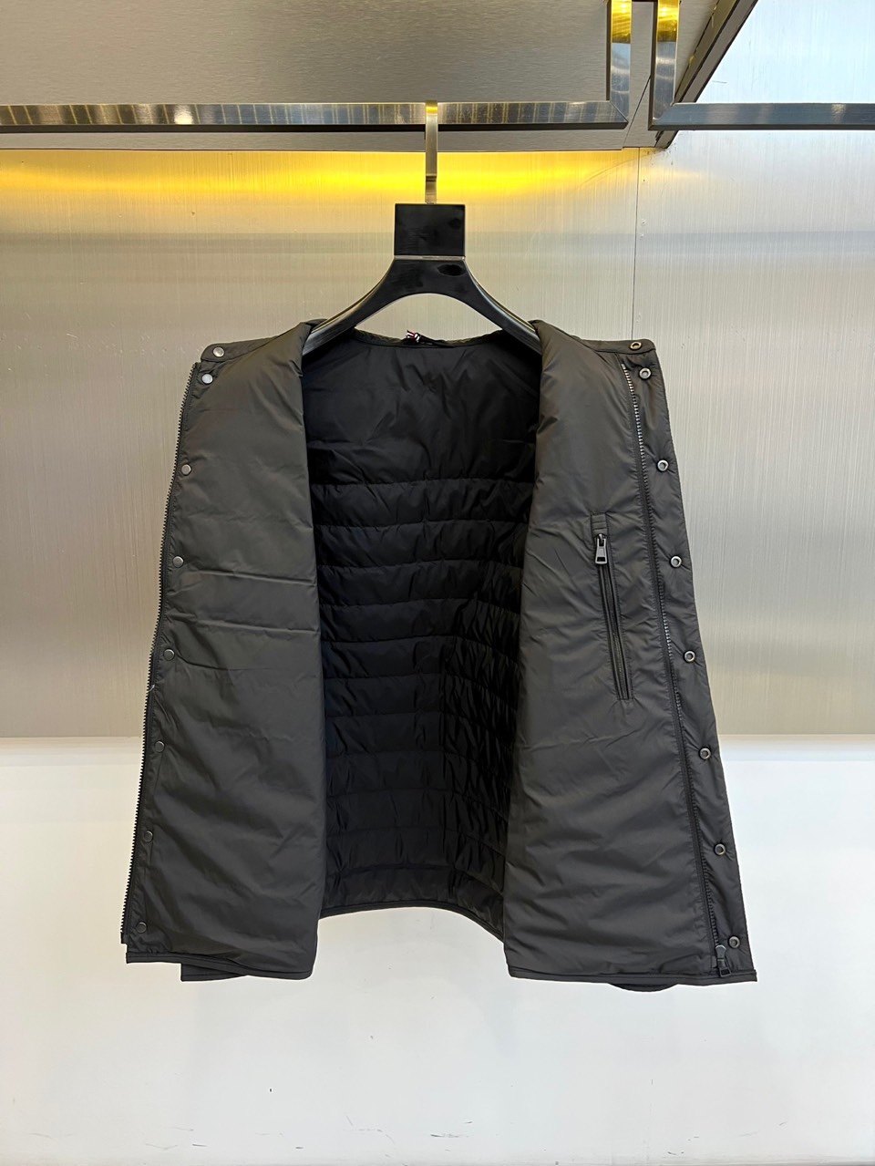 Mon蒙口、2025秋冬新品 MONCLER曜黑经典羽绒服。这款黑色羽绒服采用翻驳领设计，领口内侧饰有红