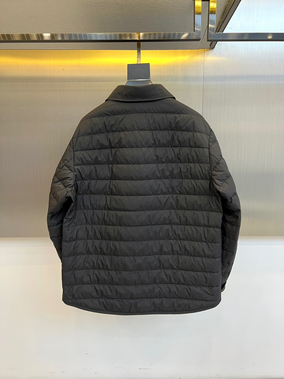 Mon蒙口、2025秋冬新品 MONCLER曜黑经典羽绒服。这款黑色羽绒服采用翻驳领设计，领口内侧饰有红