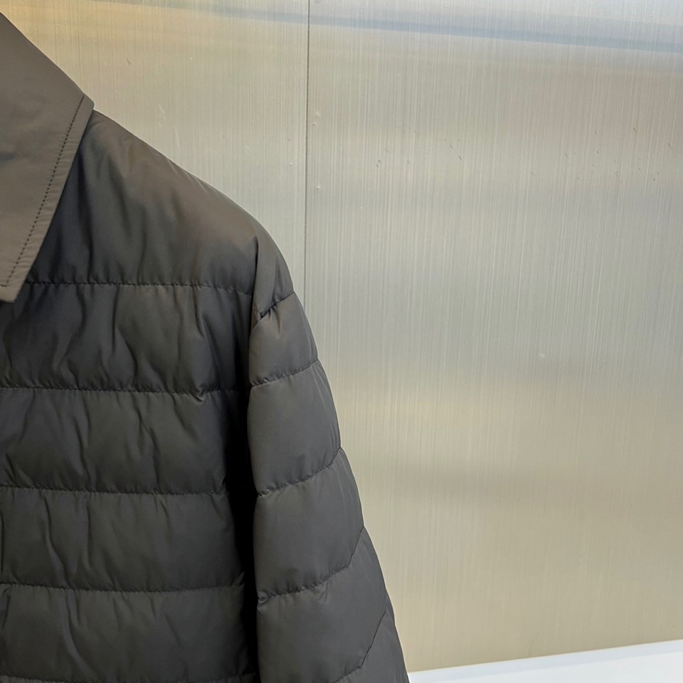 Mon蒙口、2025秋冬新品 MONCLER曜黑经典羽绒服。这款黑色羽绒服采用翻驳领设计，领口内侧饰有红