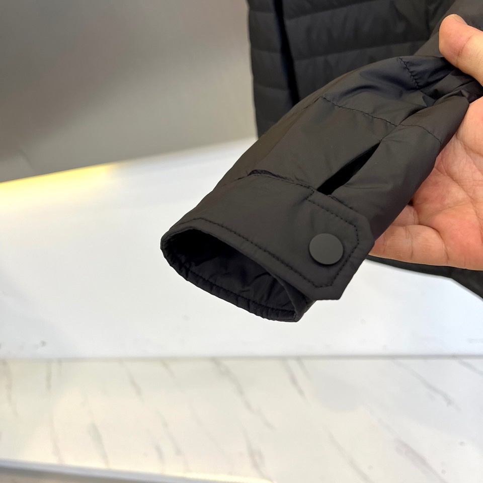 Mon蒙口、2025秋冬新品 MONCLER曜黑经典羽绒服。这款黑色羽绒服采用翻驳领设计，领口内侧饰有红