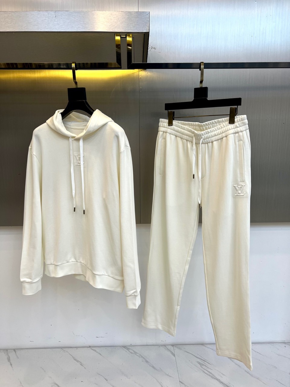 1v威登、2025秋冬新品 LOUIS VUITTON都市运动套装。白色连帽卫衣采用立体剪裁搭配可调节抽