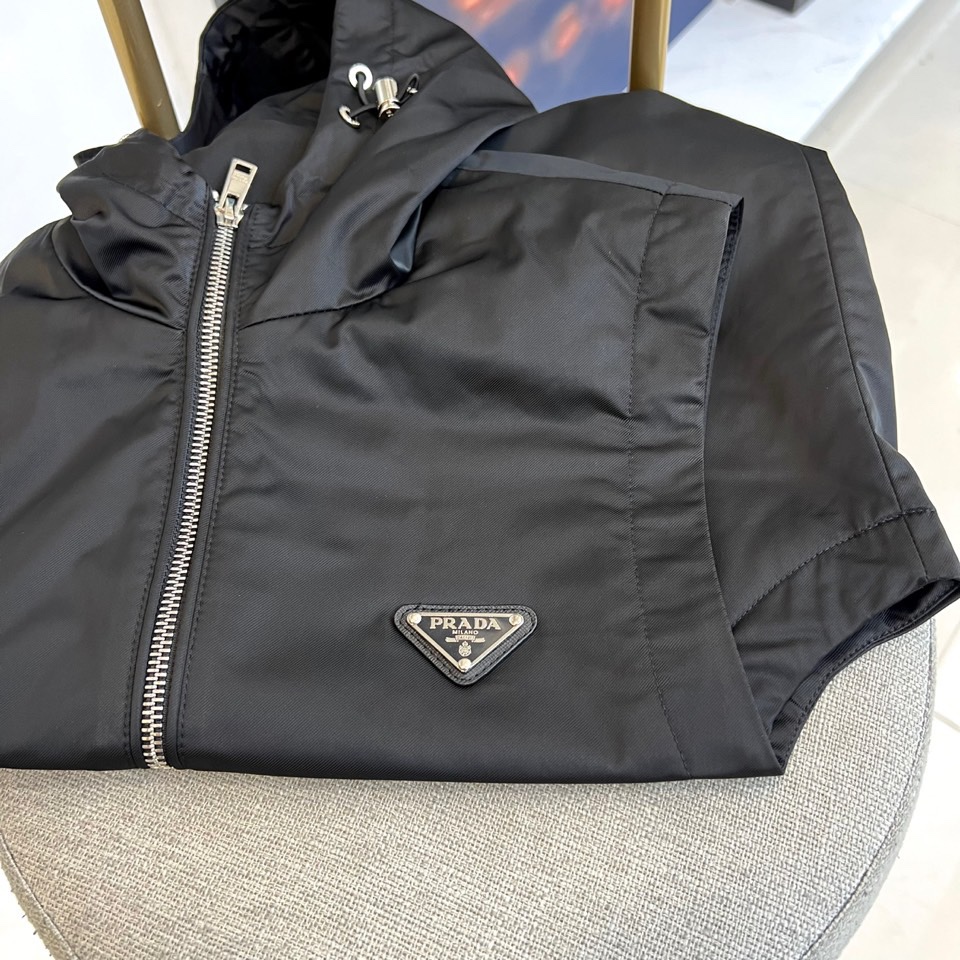 Prad普拉、25s秋冬新品男士连帽马甲。这款无袖连帽马甲以利落剪裁与机能美学打破常规——正面金属拉链开