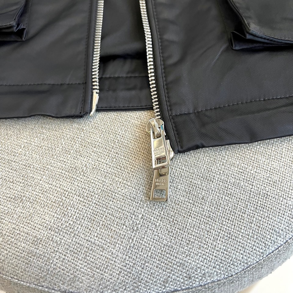 Prad普拉、25s秋冬新品男士连帽马甲。这款无袖连帽马甲以利落剪裁与机能美学打破常规——正面金属拉链开