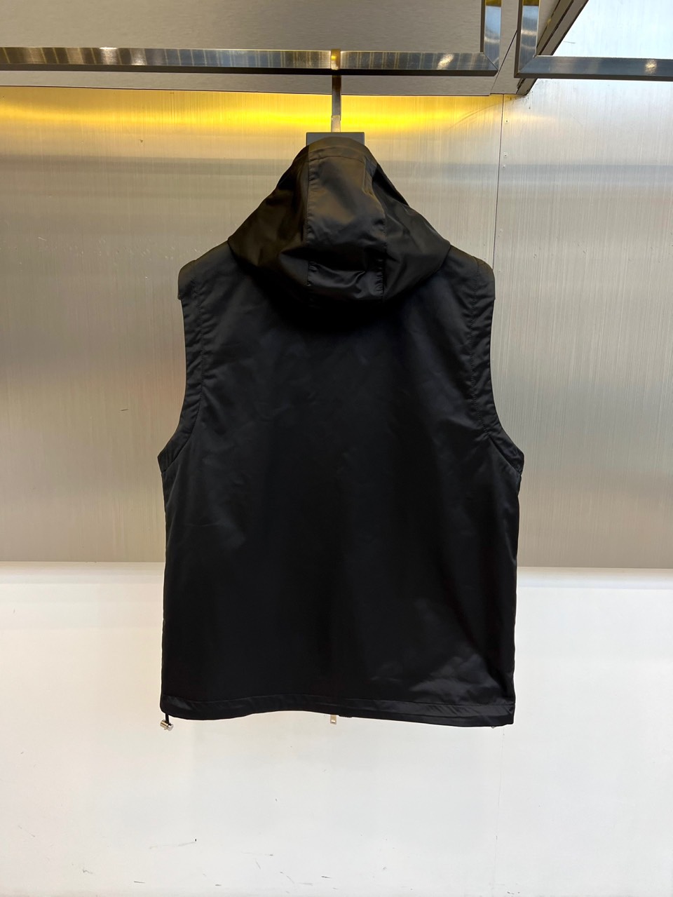 Prad普拉、25s秋冬新品男士连帽马甲。这款无袖连帽马甲以利落剪裁与机能美学打破常规——正面金属拉链开