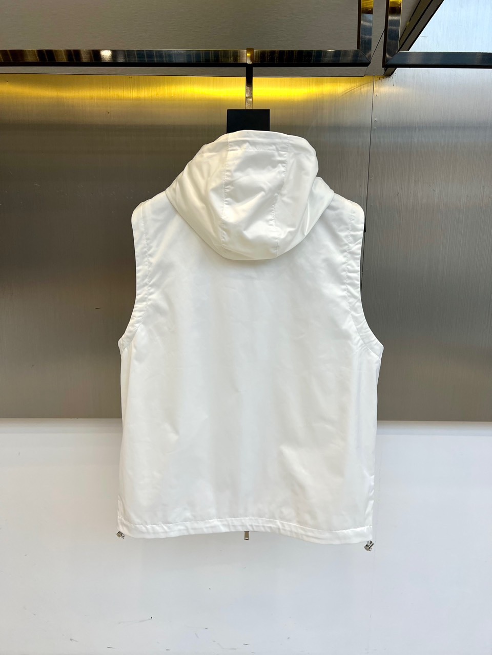 Prad普拉、25s秋冬新品男士连帽马甲。这款无袖连帽马甲以利落剪裁与机能美学打破常规——正面金属拉链开