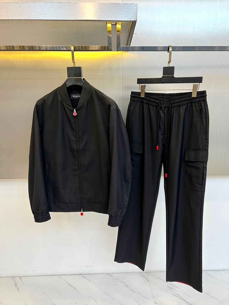 NO:726354,New Year's Jackets Pants Kiton's cool, autumn and winter new product KITON Tencel Wool Suit. A gray-toned baseball collar jacket and work style trousers form an overall look, using Tencel and wool blended materials to create a delicate texture. The jacket is three-dimensionally tailored with a red zipper closure system, ribbed cuffs and hem enhance wind resistance, and the left chest patch pocket is decorated with the brand's iconic details. The trousers of the same series are designed with an elastic waist and multi-functional large pockets, and the red drawstring echoes the color of the jacket zipper.  The Tencel component gives a silky drape feel, and the wool material ensures warmth and breathability. It can be worn as a set to create a unified urban functional style, or it can be split and matched with other items. It is suitable for business casual and outdoor scenes. Through the combination of detailed design and practical functions, it interprets KITON's aesthetic concept of integrating Italian precision genes into modern clothing. 48-56 (model is 173, 143 pounds, upper body size 50),, jackets & coats,19860909年后 夹克 裤子 Kiton奇酷、秋冬新品 KITON天丝羊毛套装. 灰色调棒球领夹克与工装风长裤组成整体造型,采用天丝与羊毛混纺材质打造细腻肌理.夹克采用立体剪裁搭配红色拉链开合系统,罗纹袖口与下摆增强防风性,左胸贴袋饰有品牌标志性细节.同系列长裤采用松紧腰头与多功能大口袋设计,红色抽绳与夹克拉链形成色彩呼应. 天丝成分赋予丝滑垂坠感,羊毛材质保证保暖透气性.既可成套穿着打造统一都市机能风,也可拆分搭配其他单品.适合商务休闲与户外场景,通过细节设计与实用功能的结合,诠释KITON将意式精工基因融入现代着装的美学理念.48-56（模特173,143斤上身50码）,,jackets & coats,,Men's clothing