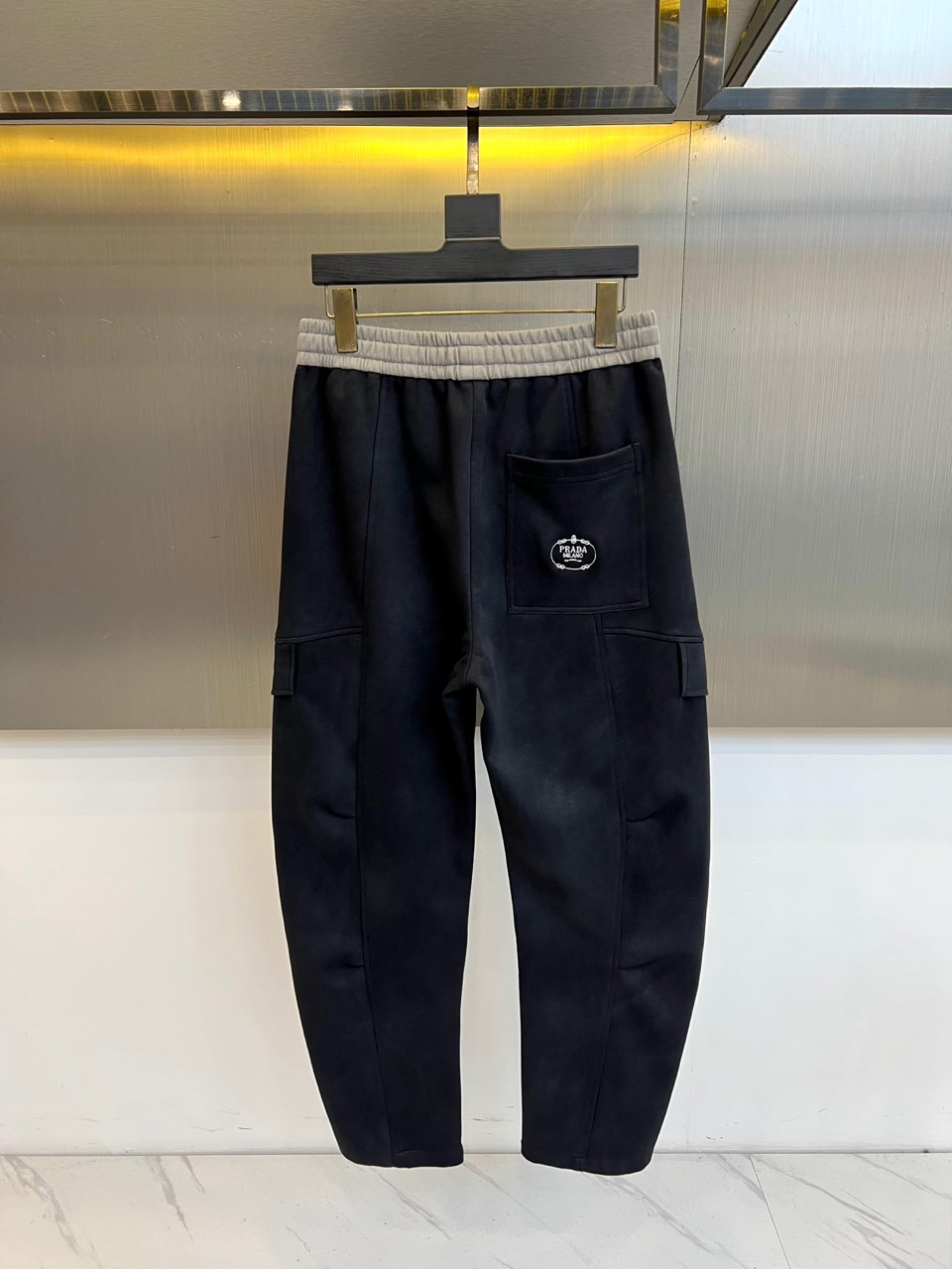 PRAD普拉、2025秋冬新品男士弯刀裤休闲裤，以宽松的直筒剪廓形重新定义当代休闲风格。裤腰采用可调节的