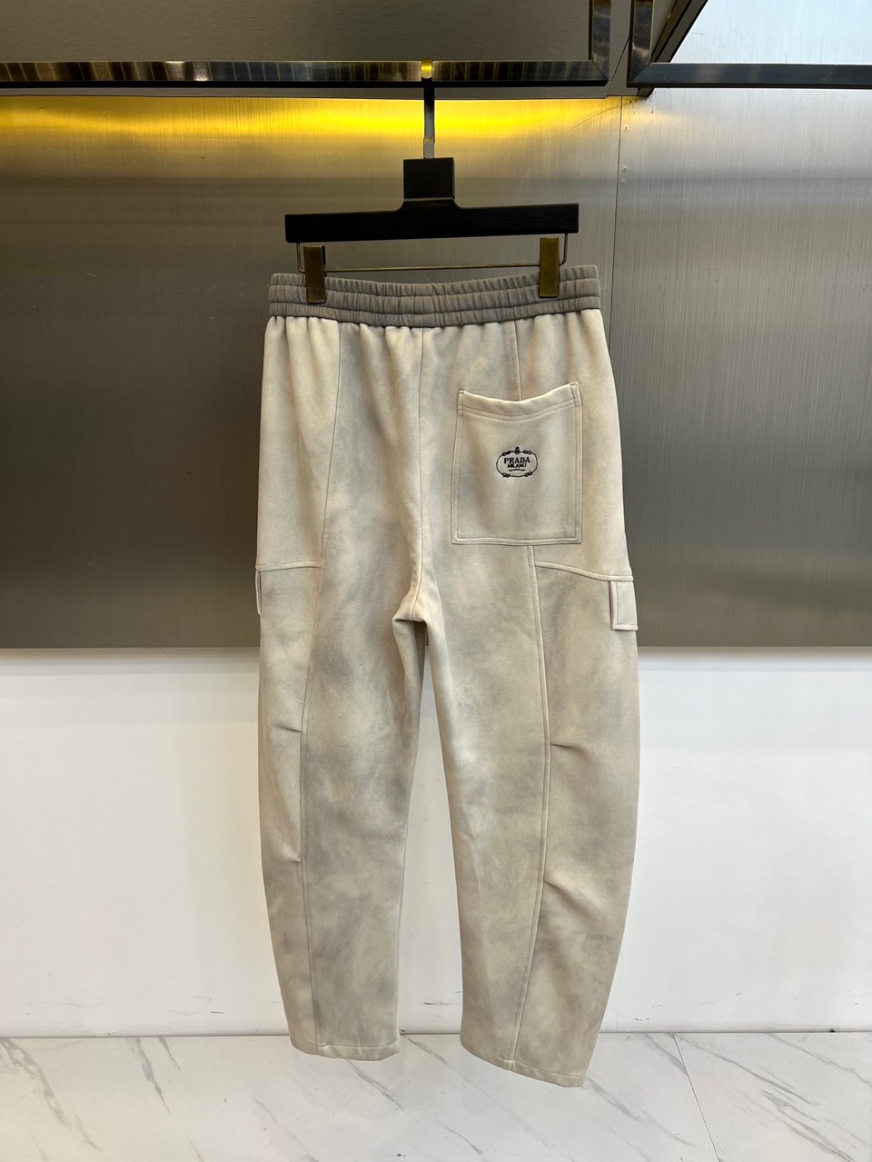 PRAD普拉、2025秋冬新品男士弯刀裤休闲裤，以宽松的直筒剪廓形重新定义当代休闲风格。裤腰采用可调节的