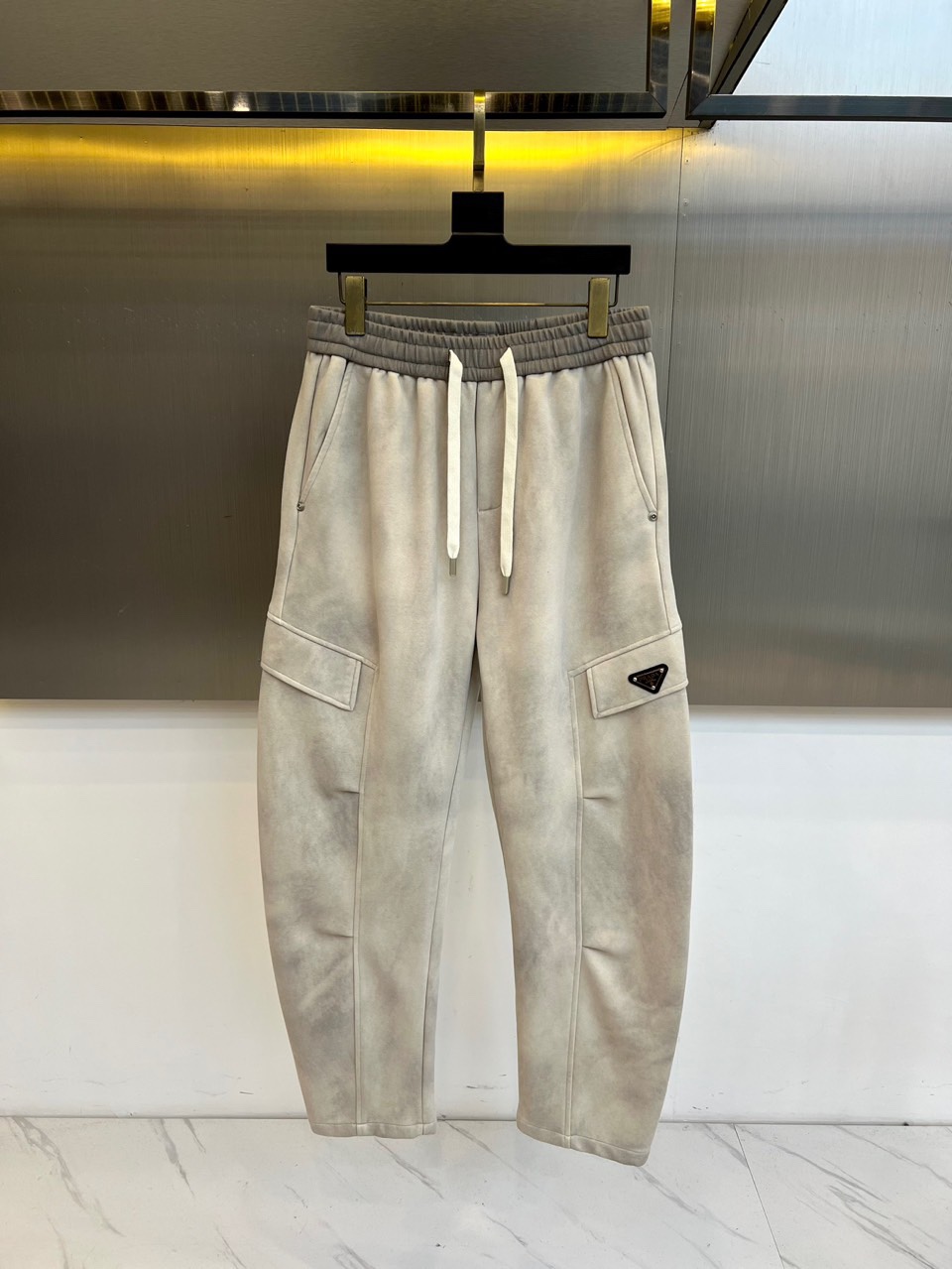 PRAD普拉、2025秋冬新品男士弯刀裤休闲裤，以宽松的直筒剪廓形重新定义当代休闲风格。裤腰采用可调节的