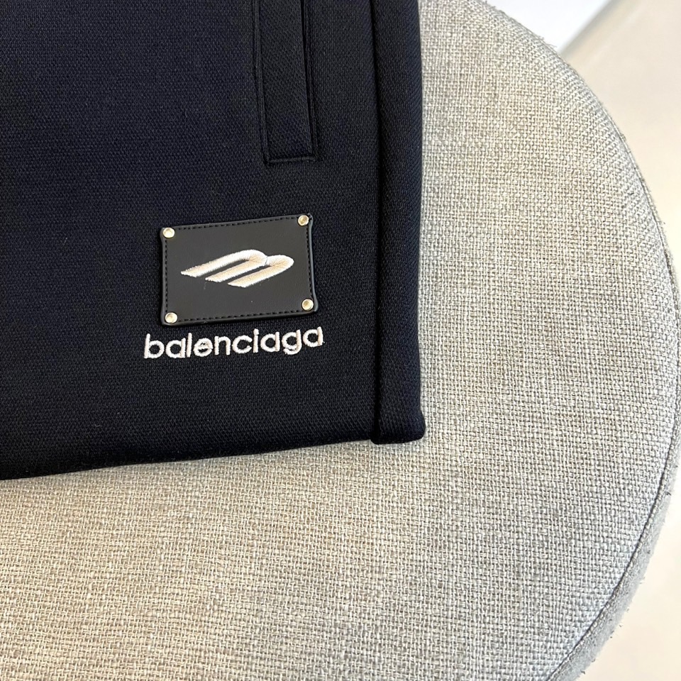 BALENCIAGA巴黎世家、2025秋冬新品男士束脚运动长裤，这款黑色长裤采用立体剪裁的束脚设计，腰部