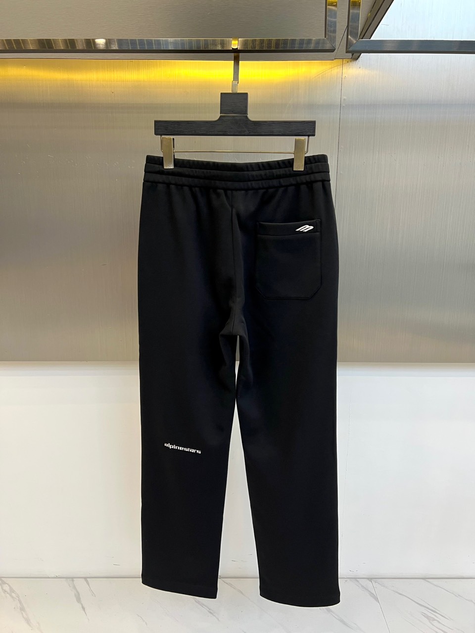 BALENCIAGA巴黎世家、2025秋冬新品男士束脚运动长裤，这款黑色长裤采用立体剪裁的束脚设计，腰部