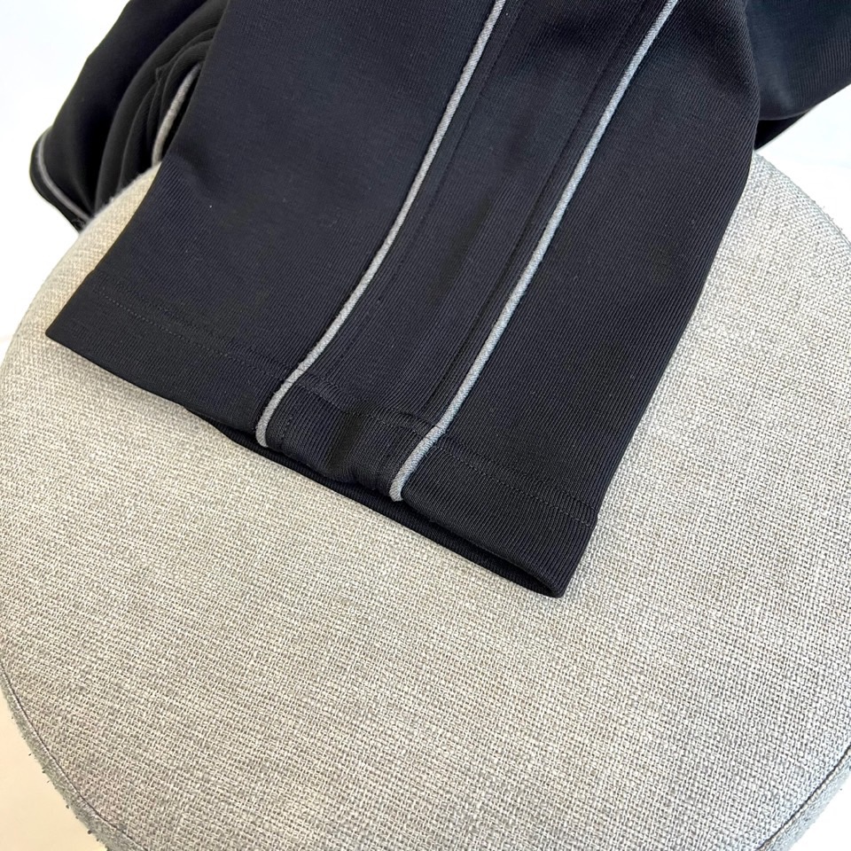 Mon蒙口、2025秋冬新品风格运动休闲裤。这款运动裤采用蒙口标志性设计，裤身两侧饰有浅灰色条纹，左侧裤