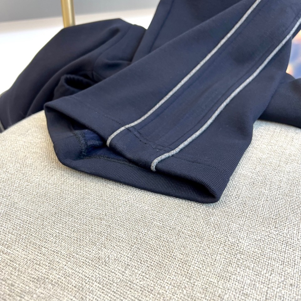 Mon蒙口、2025秋冬新品风格运动休闲裤。这款运动裤采用蒙口标志性设计，裤身两侧饰有浅灰色条纹，左侧裤