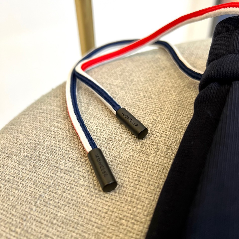 Mon蒙口、2025秋冬新品风格运动休闲裤。这款运动裤采用蒙口标志性设计，裤身两侧饰有浅灰色条纹，左侧裤