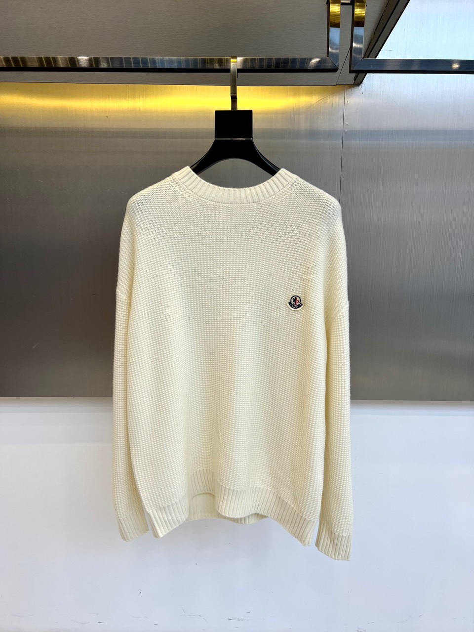 Mon蒙口、2025秋冬新品 微阔棒针羊毛针织衫。采用100%精选绵羊毛织就，米白色调呈现柔和质感。圆领