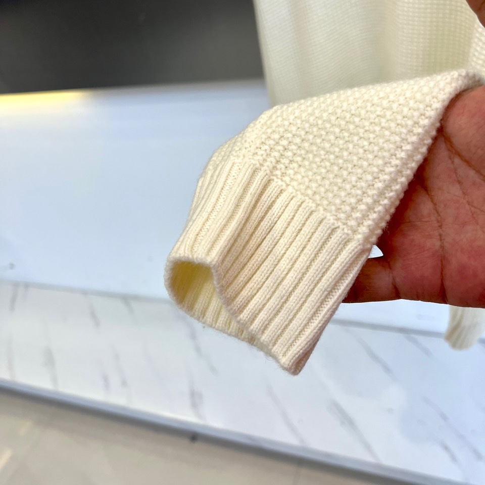 Mon蒙口、2025秋冬新品 微阔棒针羊毛针织衫。采用100%精选绵羊毛织就，米白色调呈现柔和质感。圆领