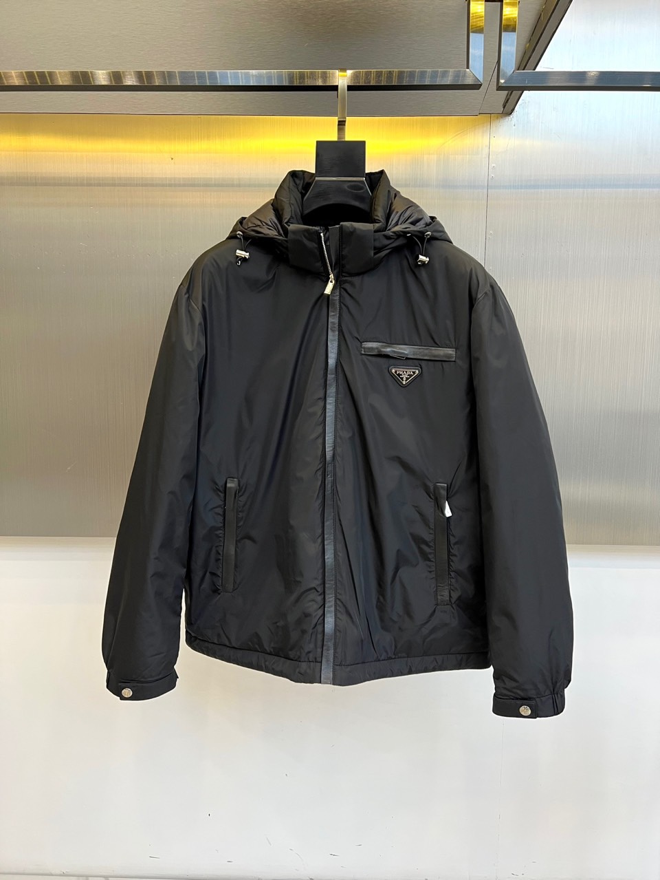 Prada普拉、2025秋冬新品羽绒服，以经典黑色演绎现代极简美学。这款羽绒服采用100%聚酰胺面料打造