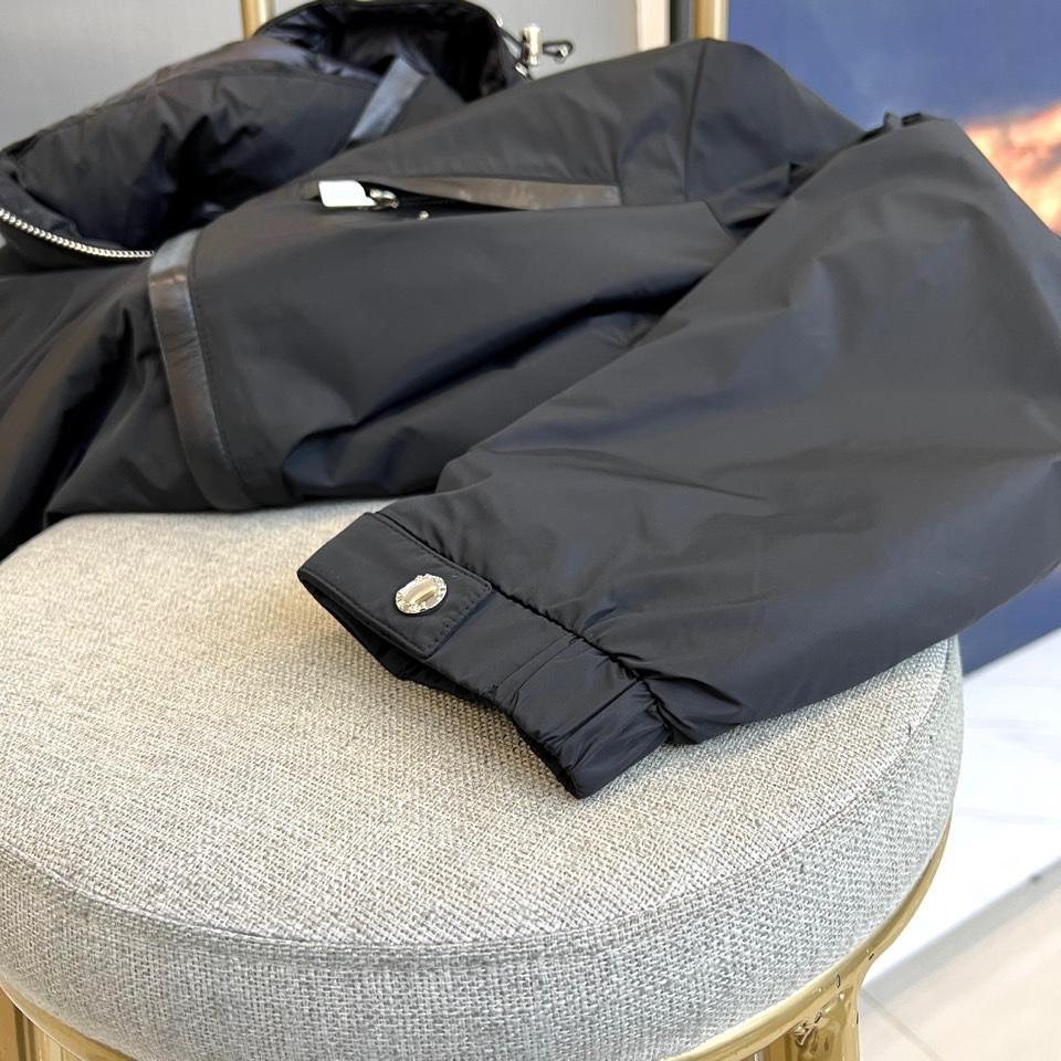 Prada普拉、2025秋冬新品羽绒服，以经典黑色演绎现代极简美学。这款羽绒服采用100%聚酰胺面料打造