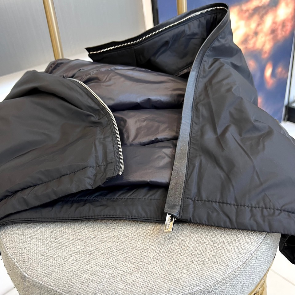 Prada普拉、2025秋冬新品羽绒服，以经典黑色演绎现代极简美学。这款羽绒服采用100%聚酰胺面料打造