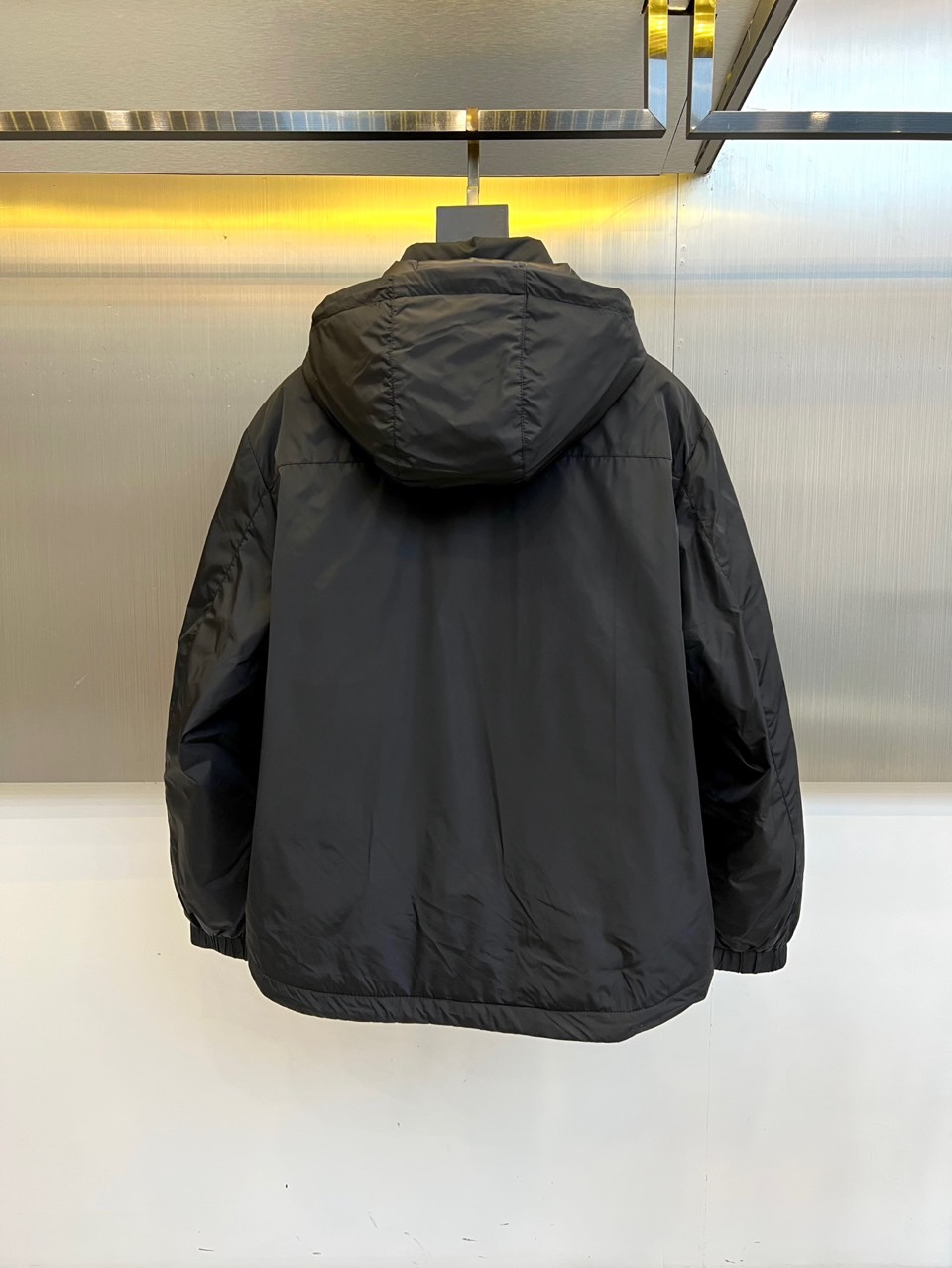 Prada普拉、2025秋冬新品羽绒服，以经典黑色演绎现代极简美学。这款羽绒服采用100%聚酰胺面料打造