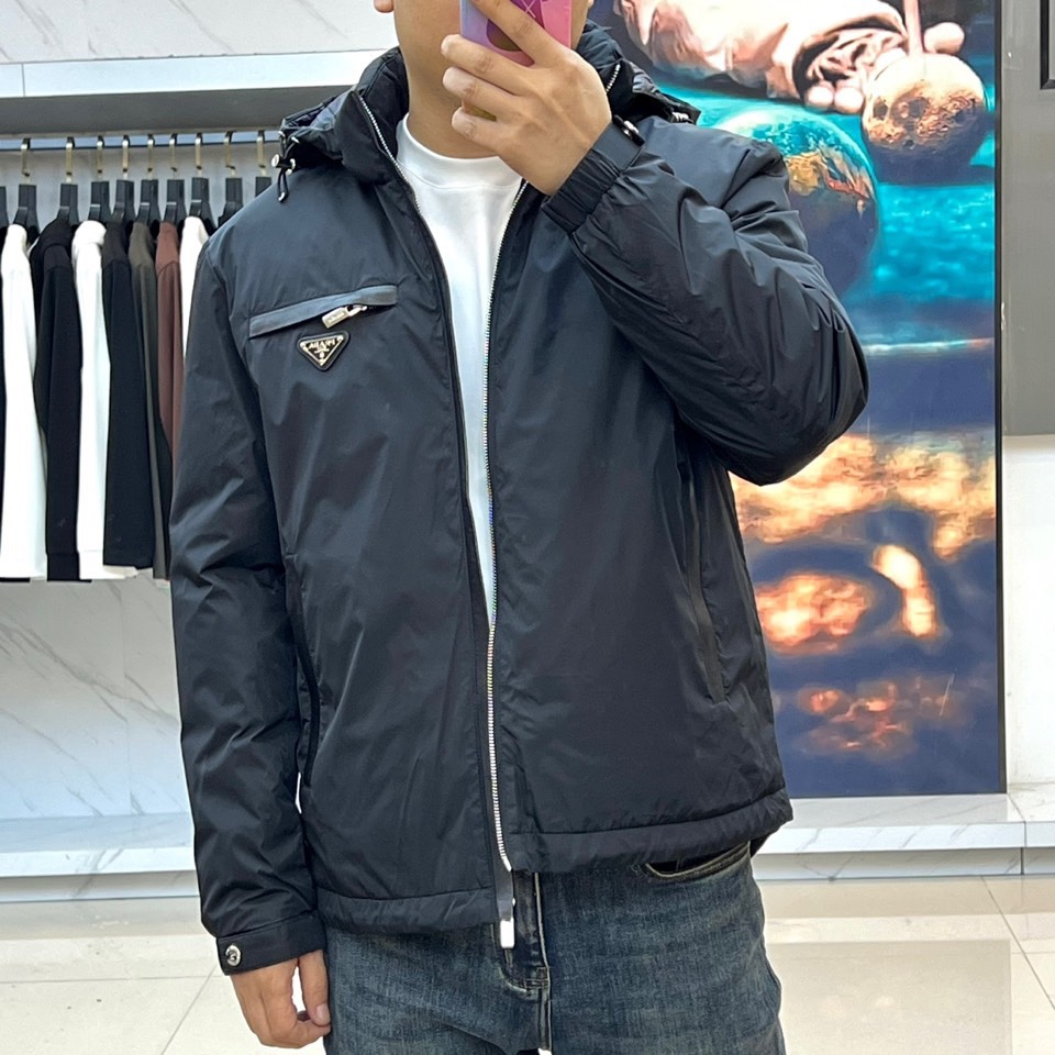 Prada普拉、2025秋冬新品羽绒服，以经典黑色演绎现代极简美学。这款羽绒服采用100%聚酰胺面料打造