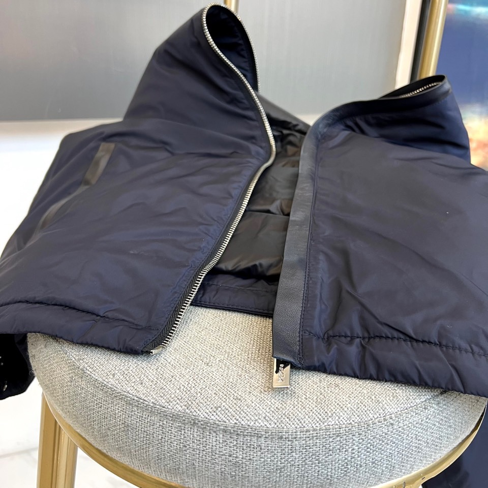 Prada普拉、2025秋冬新品羽绒服，以经典黑色演绎现代极简美学。这款羽绒服采用100%聚酰胺面料打造