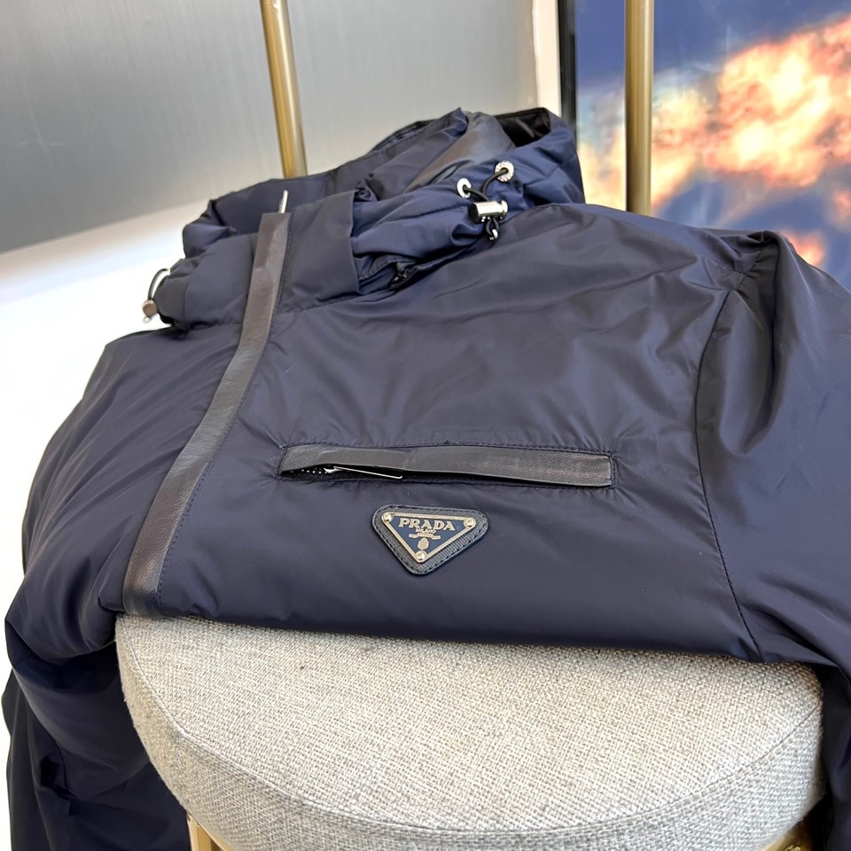 Prada普拉、2025秋冬新品羽绒服，以经典黑色演绎现代极简美学。这款羽绒服采用100%聚酰胺面料打造