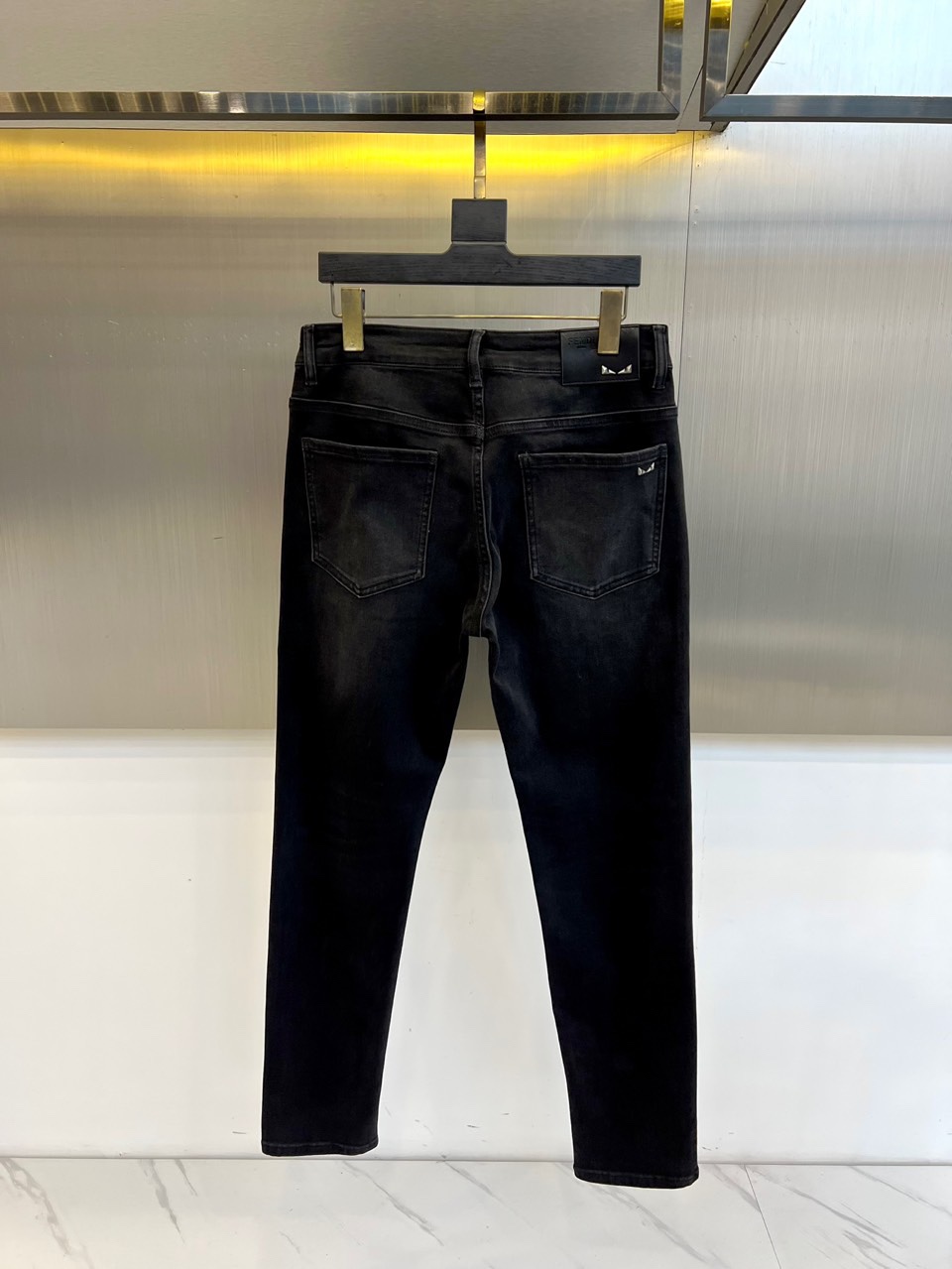 Fend芬迪、2025秋冬新品黑色牛仔裤，以深邃纯黑诠释意式奢华美学。后腰处装饰标志性棕色压纹皮质标牌，