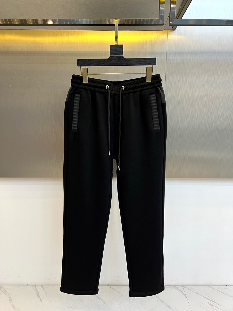 NO:726347,Years later, Loro Piana's new casual trousers series for autumn and winter. This series uses a scientific ratio of 82 acetate fiber and 18 Tencel. The fabric shows a delicate and slightly glossy feel. The Tencel component gives excellent drape and skin-friendly touch. The elastic waistband is equipped with an adjustable drawstring design. The two sides of the trousers are decorated with three-dimensional vertical stripes. The slightly curled details on the trousers' legs add a fashionable layer. Available in three colors: off-white, dark brown, and black.  Acetate fiber provides silky texture and anti-wrinkle performance, while Tencel material ensures breathability and environmental protection. The vertical stripe elements extend the visual lines, and the elastic waistband takes into account comfort and convenience. It can be paired with a sweater to create an urban casual look, or with a casual suit to interpret a business casual style. Through the combination of material innovation and practical aesthetics, Loro Piana interprets the design philosophy of integrating Italian luxury genes into daily wear. 48-56 (model 173, 143 pounds, upper body size 50),, loro piana, business suit,19860909年后 Loro Piana诺悠翩雅、秋冬新品休闲长裤系列. 本系列采用82醋酯纤维与18天丝的科学配比,面料呈现细腻微光泽感,天丝成分赋予卓越垂坠性和亲肤触感.松紧腰头搭配可调节抽绳设计,裤身两侧装饰立体竖条纹,裤脚微卷边细节增添时尚层次.米白、深棕、黑色三色可选, 醋酯纤维提供丝滑质感与抗皱性能,天丝材质确保透气环保.竖条纹元素延伸视觉线条,松紧腰头兼顾舒适性与便利度.可搭配针织衫打造都市休闲造型,或配合休闲西装演绎商务休闲风格.通过材质创新与实用美学的结合,诠释Loro Piana将意式奢华基因融入日常穿着的设计哲学.48-56（模特173,143斤上身50码）,,loro piana,business suit,,Men's clothing