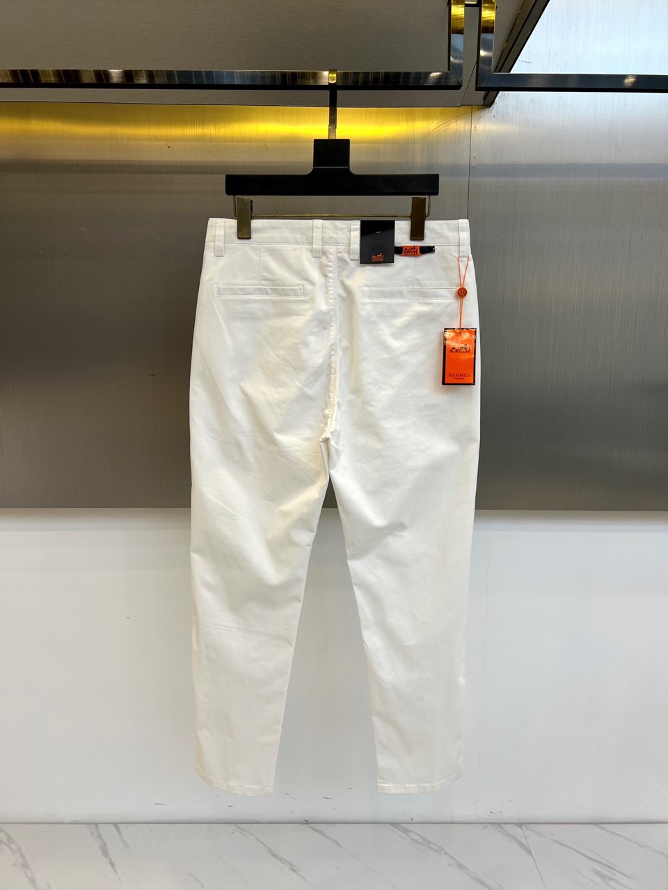 H爱马仕、2025秋冬新品系列以精湛工艺与简约美学为核心，推出了多款奢华长裤。图中白色长裤采用直筒剪裁，