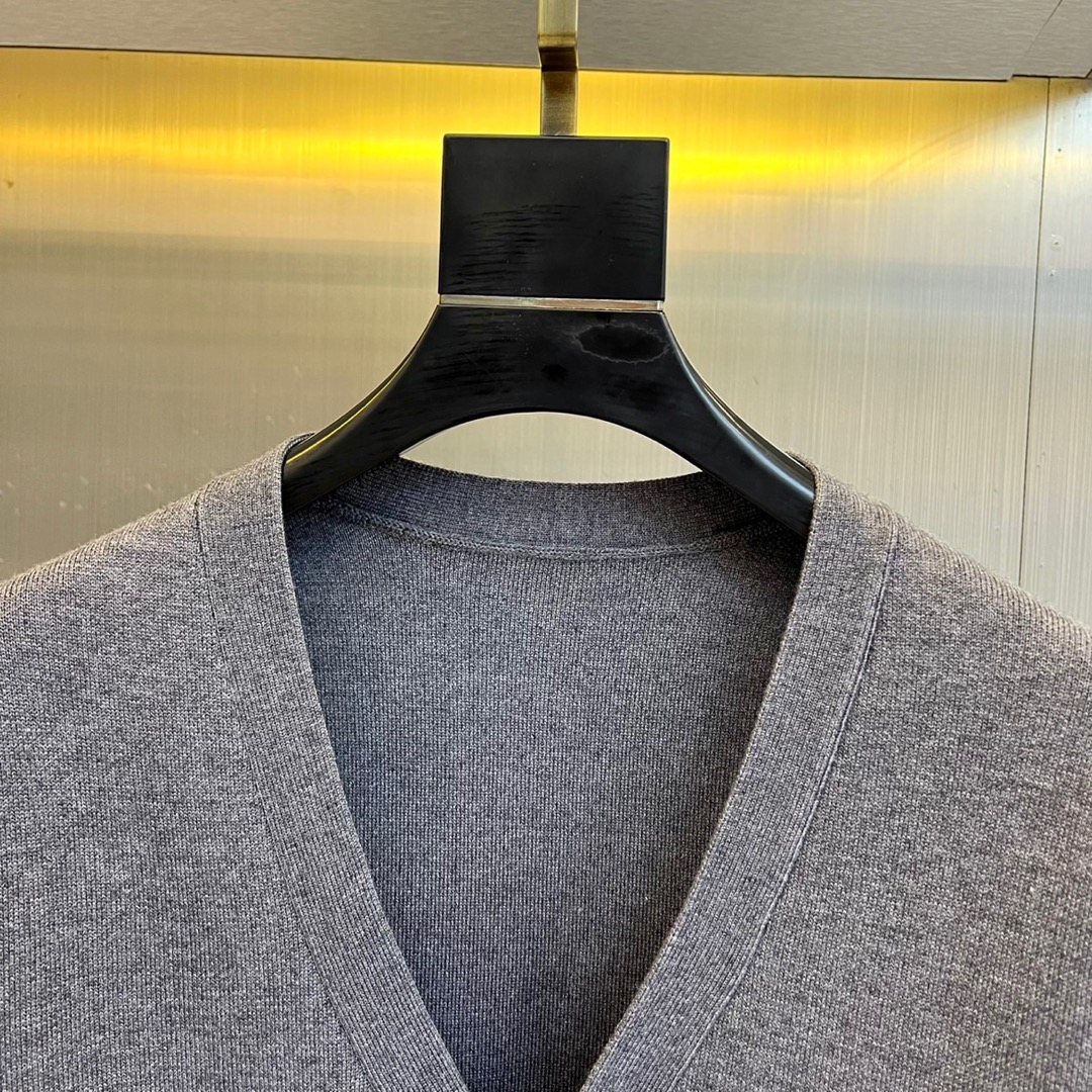 1v威登、2025秋冬新品针织开衫，这款灰色开衫采用V领设计搭配单排纽扣开合，两侧设有实用贴袋。衣袖满铺