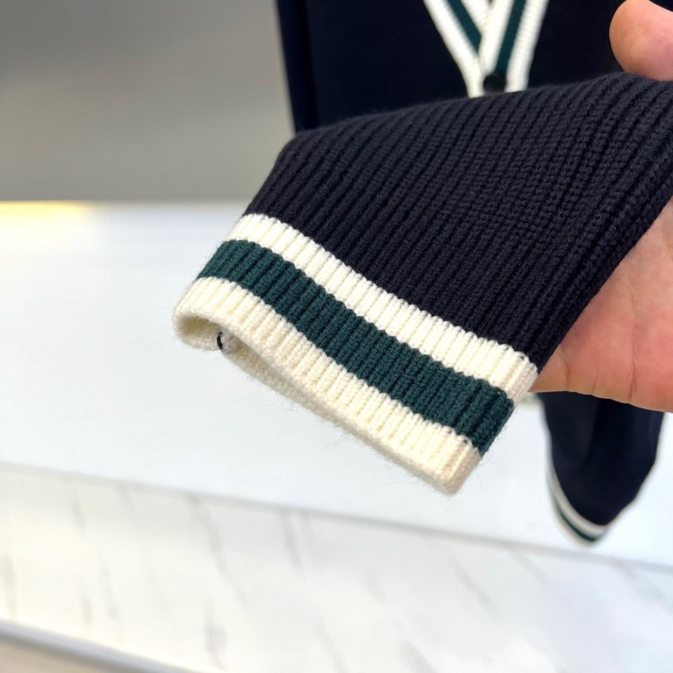 Dg杜嘉班纳、2025秋冬新品男士DG经典羊毛🐑针织开衫。这款藏青色开衫采用经典V领设计，领口、袖口及下