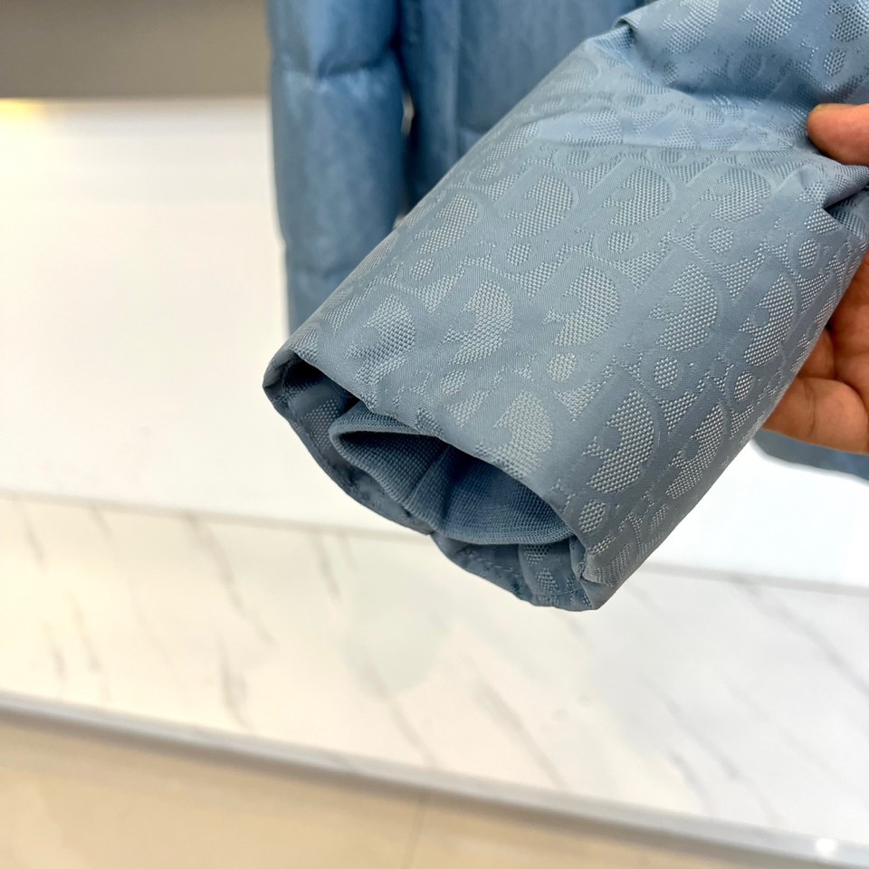 Dio迪奥（白鹅绒）、2025秋冬新品 DIOR羽绒服。浅蓝色短款设计搭配立领结构，通过精密拉链系统实现