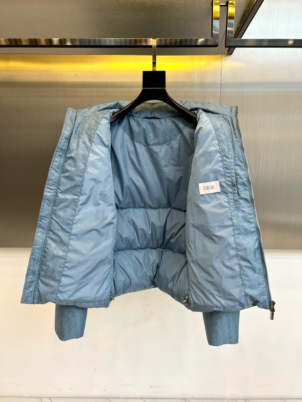 Dio迪奥（白鹅绒）、2025秋冬新品 DIOR羽绒服。浅蓝色短款设计搭配立领结构，通过精密拉链系统实现